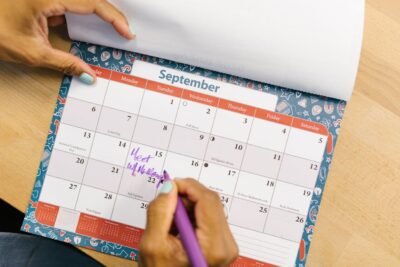 Na imagem, pessoa realizando gestão de tempo com calendário